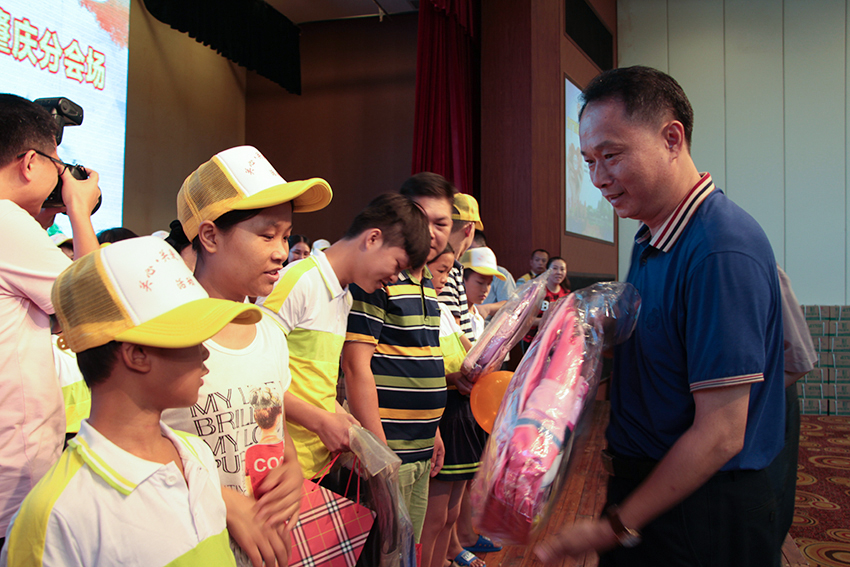 9.梧州市總工會黨組書記、常務副主席梁耀忠為農民工子女贈送書包、文具.jpg